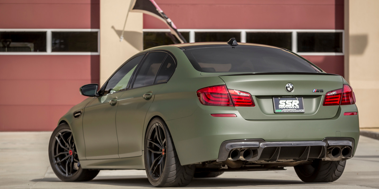 A Military Green BMW M5 With Vorsteiner Wheels And Aero Installed